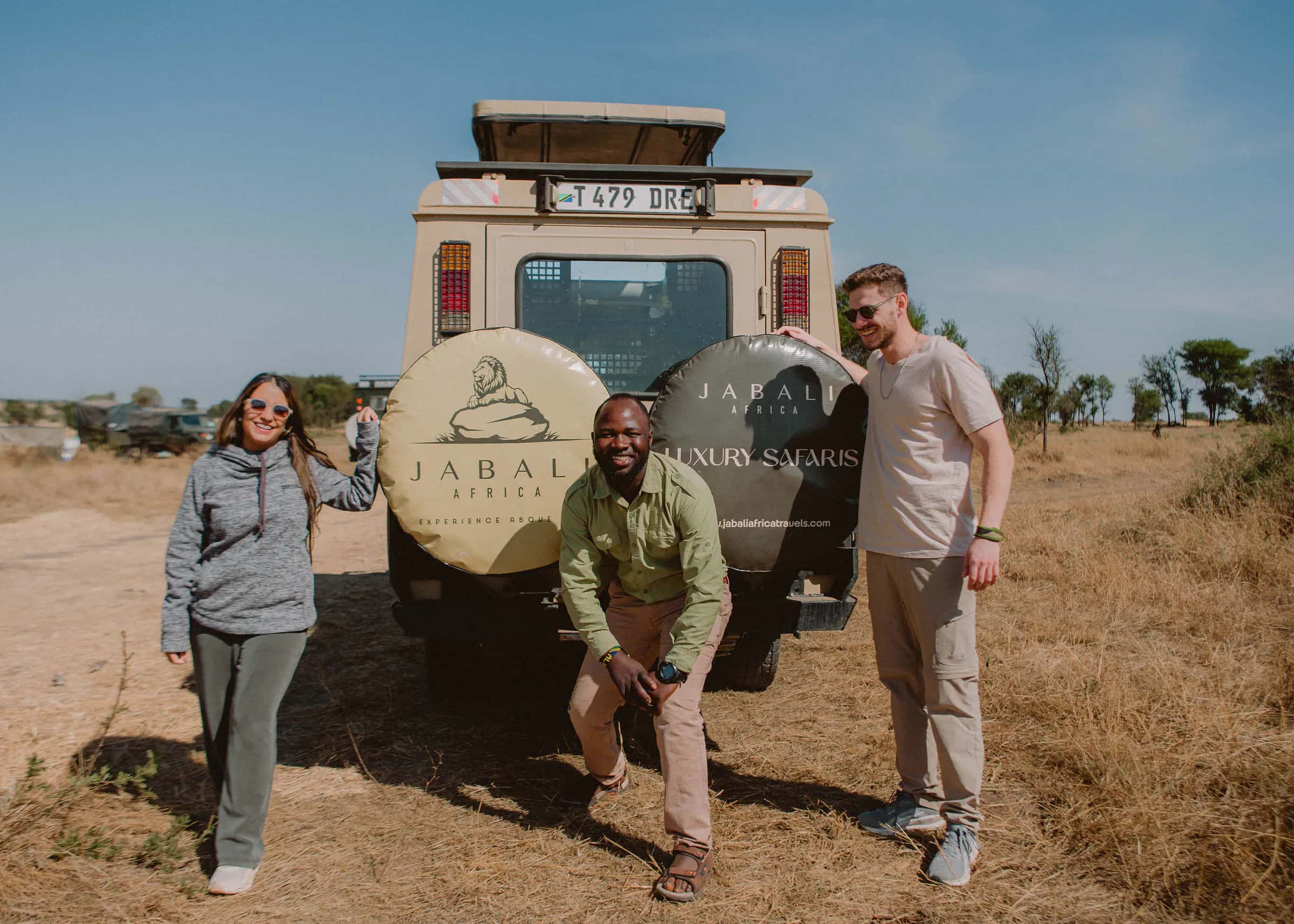 Jabali guide with guests beside the safari vehicle