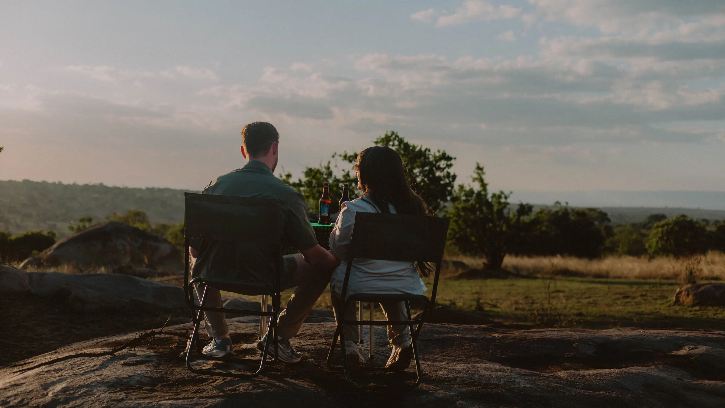 Couple with sundowner drinks on a kopje